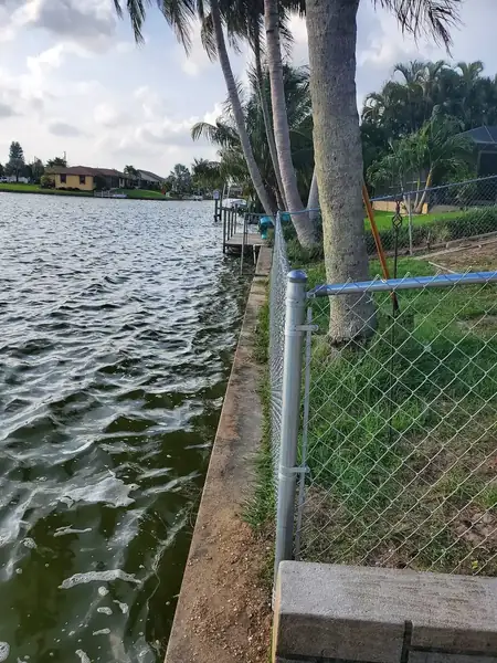 Galvanized chain link fence along a waterfront property